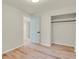 A bedroom with neutral walls, wood floors, light blue door, and a closet offers a simple design at 8304 Eaton Way, Arvada, CO 80003