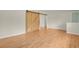 Open-concept living area featuring light hardwood flooring and a sliding barn door at 8304 Eaton Way, Arvada, CO 80003