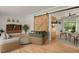 A sunlit living room featuring hardwood floors and a sliding barn door leading to an adjacent dining area at 8304 Eaton Way, Arvada, CO 80003