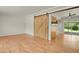 Spacious living room with hardwood floors, barn door feature, and sliding glass doors at 8304 Eaton Way, Arvada, CO 80003