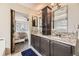 Bathroom featuring double granite vanity and access to primary bedroom via sliding barn door at 9241 Roadrunner St, Highlands Ranch, CO 80129