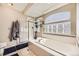 Bright bathroom showcasing a glass enclosed shower, soaking tub, and light-filtering glass block window at 9241 Roadrunner St, Highlands Ranch, CO 80129