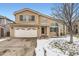 Charming tan home featuring an attached two car garage, covered porch, and an arched window at 9241 Roadrunner St, Highlands Ranch, CO 80129