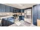 Contemporary kitchen with stainless steel refrigerator, oven, light countertops and navy blue cabinets at 9241 Roadrunner St, Highlands Ranch, CO 80129