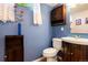 Charming bathroom featuring blue walls, a wooden vanity, and bright lighting at 6868 S Birch Way, Centennial, CO 80122