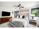 Well-lit bedroom featuring hardwood floors, cozy bed with plush pillows, decorative skis and neutral decor at 600 Cascade Dr, Golden, CO 80403