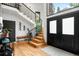 Bright foyer with hardwood floors, staircase with wrought iron railings, bench and decorative plants at 600 Cascade Dr, Golden, CO 80403