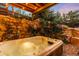 Inviting hot tub surrounded by stone walls, lush greenery, and ambient lighting for relaxation at 600 Cascade Dr, Golden, CO 80403