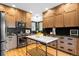 Modern kitchen with wood cabinets, stainless steel appliances and a marble island with black countertops and stainless steel appliances at 600 Cascade Dr, Golden, CO 80403
