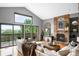 Cozy living room features a brick fireplace, vaulted ceiling, and sliding doors to the deck at 600 Cascade Dr, Golden, CO 80403