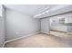 Finished basement room with neutral carpet, open to a kitchen area at 2731 S Logan St, Englewood, CO 80113