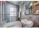 Bathroom featuring tiled walls, a pedestal sink, and a glass-enclosed shower over tub at 2731 S Logan St, Englewood, CO 80113