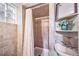 Cozy bathroom features tile flooring, shower over tub, glass block window, and updated vanity at 2731 S Logan St, Englewood, CO 80113
