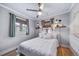 Bright bedroom with hardwood floors, a ceiling fan, and natural light from two windows at 2731 S Logan St, Englewood, CO 80113