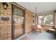 Inviting covered front porch with brick accents, swing, and a view of the neighborhood at 2731 S Logan St, Englewood, CO 80113