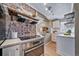 Updated kitchen with stainless steel oven, exposed brick accent wall, and bright quartz countertops at 2731 S Logan St, Englewood, CO 80113