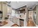 Well-lit kitchen with stainless steel dishwasher, quartz countertops, subway tile backsplash, and floating wood shelves at 2731 S Logan St, Englewood, CO 80113