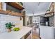 Bright open kitchen with refinished hardwood floors, quartz countertops, and stainless steel appliances at 2731 S Logan St, Englewood, CO 80113