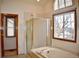 Well-lit bathroom featuring a bathtub with shower, tiled walls, and a window for natural light at 9946 Wyecliff Dr, Highlands Ranch, CO 80126