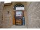 Wood front door featuring sidelights, an arched transom, and a decorative security screen at 9946 Wyecliff Dr, Highlands Ranch, CO 80126