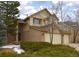 Two-story home with a two car garage, light tan siding and a brick facade at 9946 Wyecliff Dr, Highlands Ranch, CO 80126