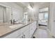 Bright bathroom featuring double sinks with modern fixtures and a large mirror with great lighting at 1575 W 68Th Ave, Denver, CO 80221