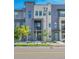 Inviting townhome featuring a private balcony, modern gray facade, and neatly landscaped front yard at 1575 W 68Th Ave, Denver, CO 80221