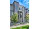 Modern townhome showcasing a private balcony, gray siding, and neatly landscaped front yard at 1575 W 68Th Ave, Denver, CO 80221
