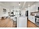 Open floor plan with modern lighting and a large kitchen island with seating at 1575 W 68Th Ave, Denver, CO 80221