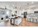 Open-concept design blends living, dining, and kitchen areas, with modern lighting and stainless steel appliances at 1575 W 68Th Ave, Denver, CO 80221