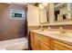 Well-lit bathroom featuring a double vanity, tile backsplash, and a shower-tub combination with stylish fixtures at 1866 S Pennsylvania St, Denver, CO 80210
