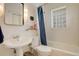 Bright bathroom features a glass block window, tiled walls, and a pedestal sink at 1866 S Pennsylvania St, Denver, CO 80210