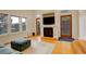 Bright living room with a cozy fireplace, TV, wood floors, and outdoor access through glass doors at 1866 S Pennsylvania St, Denver, CO 80210