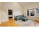 Cozy living room with a comfortable sofa, ottoman, hardwood floors, and natural light from multiple windows at 1866 S Pennsylvania St, Denver, CO 80210