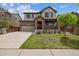Charming two-story home features a well-manicured lawn, brick accents, and inviting front porch at 25466 E 4Th Pl, Aurora, CO 80018