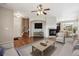 A well-lit living room boasts a fireplace, a ceiling fan, and wood floors at 25466 E 4Th Pl, Aurora, CO 80018
