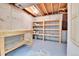 Unfinished basement with a sturdy workbench, open shelving, and exposed ceiling at 13134 Deneb Dr, Lone Tree, CO 80124