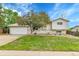 Charming gray home with a two-car garage, lush lawn, and a beautiful tree in the front yard at 13134 Deneb Dr, Lone Tree, CO 80124