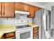 Kitchen features wood cabinets, white appliances, and neutral countertops at 13134 Deneb Dr, Lone Tree, CO 80124