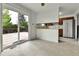Bright kitchen with tile floor, white cabinets, slider door to deck, and stainless steel refrigerator at 13134 Deneb Dr, Lone Tree, CO 80124