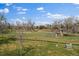 A serene backyard overlooks a greenbelt, fenced in with blue skies overhead at 7750 S Buchanan Way, Aurora, CO 80016