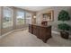 Classic home office with rich wood desk, neutral walls, large plant, and ample natural light at 7750 S Buchanan Way, Aurora, CO 80016
