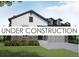 Charming exterior elevation of a home with stone accents and a two-car garage, under construction at 8925 S Riviera Way, Aurora, CO 80016