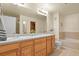 Bathroom with double sinks, a large mirror, and a separate bathtub at 1404 Whitehall Dr # C, Longmont, CO 80504