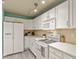 Well-lit kitchen with white cabinets, appliances, and backsplash at 1404 Whitehall Dr # C, Longmont, CO 80504