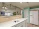 Bright kitchen with white countertops and cabinets, featuring a breakfast bar and view of the living room at 1404 Whitehall Dr # C, Longmont, CO 80504