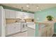 Well-lit kitchen with white cabinets, modern appliances, and a breakfast bar for casual dining at 1404 Whitehall Dr # C, Longmont, CO 80504