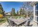 Outdoor patio has a large dining table set for eight, with a grassy yard and privacy fence in the background at 3343 W 109Th Cir, Westminster, CO 80031