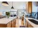 Open kitchen and living room space with granite countertops and modern hanging lights at 3343 W 109Th Cir, Westminster, CO 80031