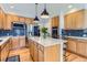 Modern kitchen with wooden cabinets, a center island, stainless steel appliances, and tile backsplash at 3343 W 109Th Cir, Westminster, CO 80031
